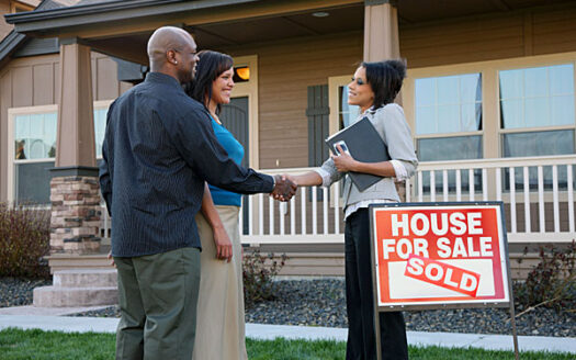 realtor shakes hands with clients